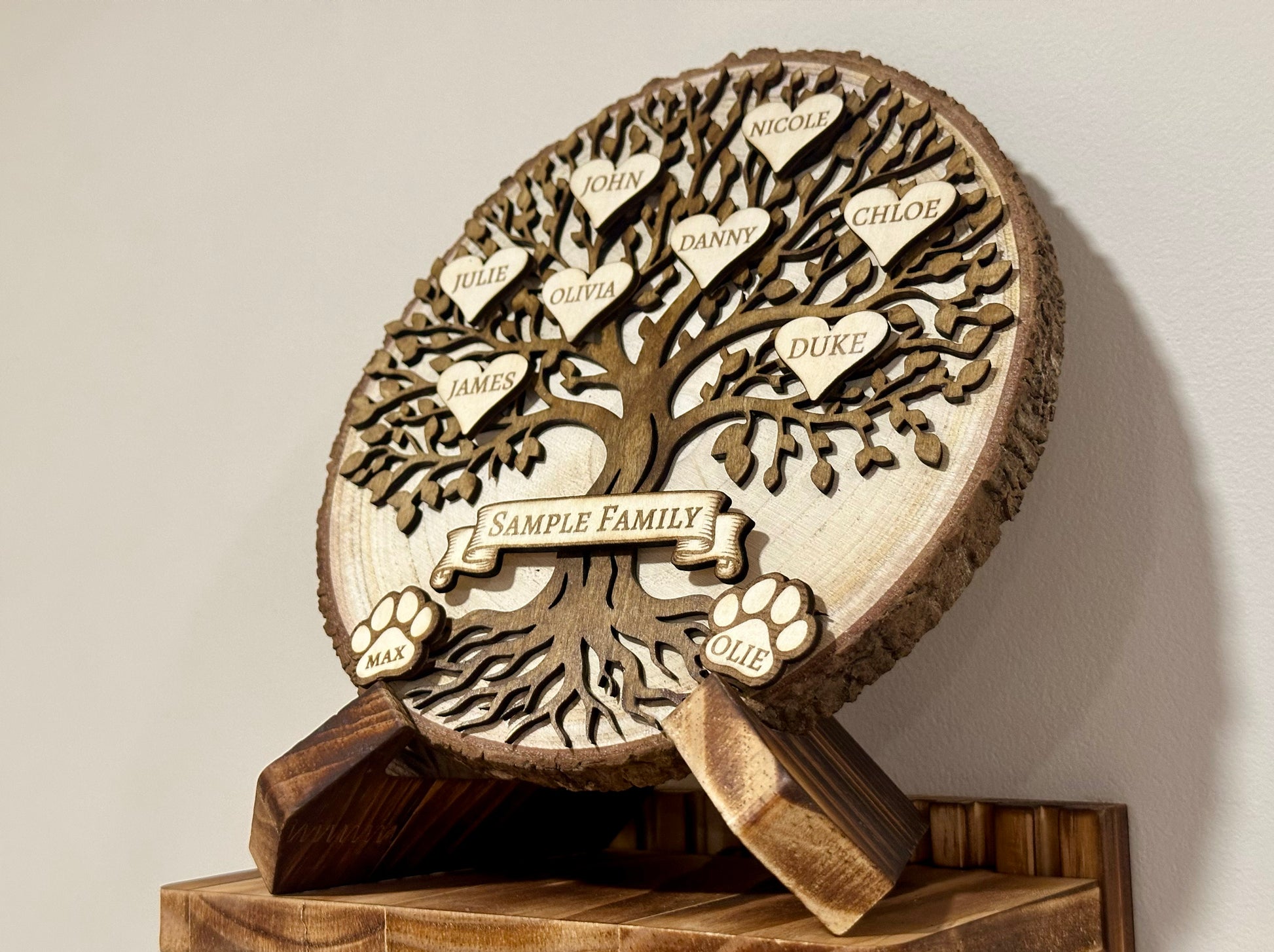 Wooden family tree with engraved names on a beige background