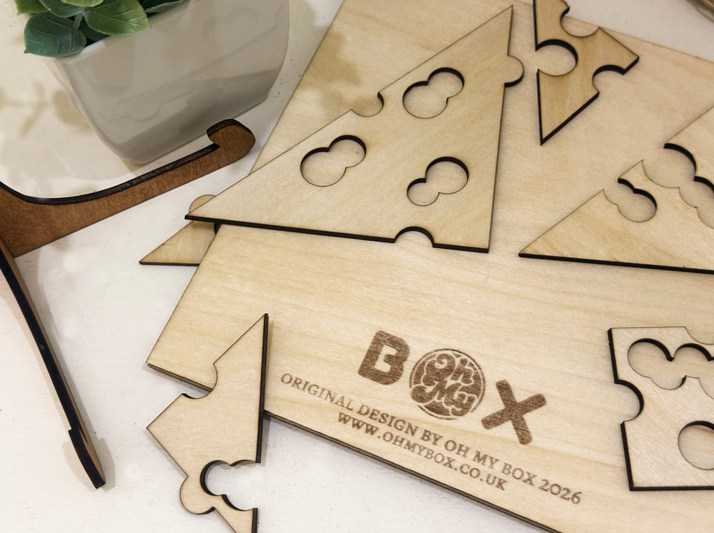 Wooden puzzle pieces with 'OH MY BOX' branding on a white surface.