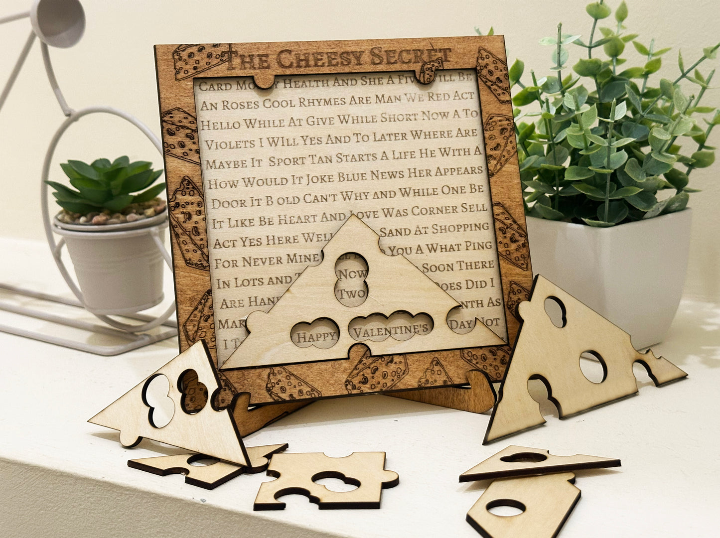 Wooden cheese-shaped puzzle with a decorative frame on a table with plants.